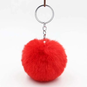 Close-up of bright red faux rabbit fur pom pom keychain with silver metal ring