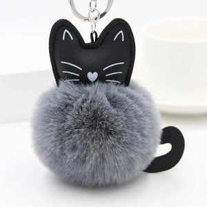 Detailed macro shot of a gray plush cat keychain with soft faux fur and metallic ring