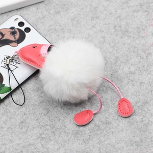 Porte-clés chaton en peluche blanche avec pattes en cuir rose sur fond en feutre