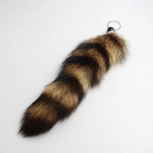 Detail of oversized faux fur fox tail keychain with black and brown striped natural pattern