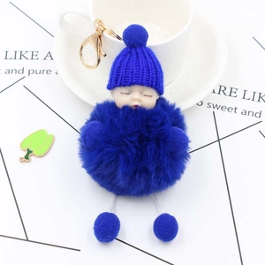 Detail view of royal blue plush sleeping baby doll keychain with golden lobster clasp