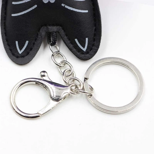 Detailed close-up of the black leather cat keychain with a silver metal lobster clasp