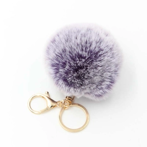 Close-up of fluffy purple faux rabbit fur pompom keychain with gold metal lobster clasp