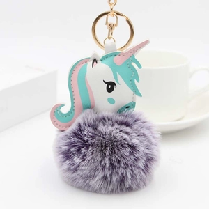 Détail d'un porte-clés licorne en peluche avec boule de fausse fourrure violette et fermoir