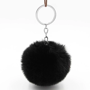 Macro detail of plush black faux fur pompom keychain with shiny silver metal clasp