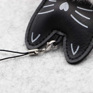 Gros plan du porte-clés chat noir avec fermoir mousqueton et détails de couture soignés