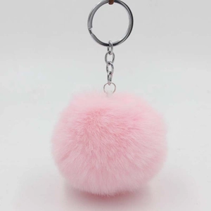 Close-up of soft pink faux rabbit fur pom pom keychain with silver metal ring