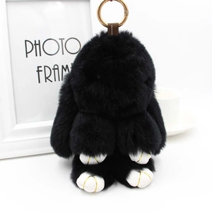 Gros plan du porte-clés lapin en peluche noir avec anneau doré et fourrure douce