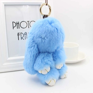 Vue détaillée du porte-clés lapin en fourrure bleu clair avec anneau doré élégant et doux