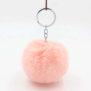 Detail of pink faux rabbit fur pom pom keychain with silver metal ring on leather strap