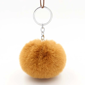 Detail shot of a soft ginger faux rabbit fur pom pom keychain with silver metal rings