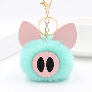 Détail de porte-clés cochon en peluche vert menthe avec finitions en cuir rose et doré