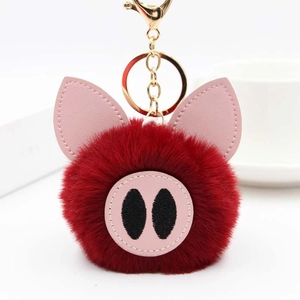 Détail macro du porte-clés cochon en peluche rouge avec oreilles en cuir PU et fermoir doré