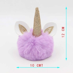 Detailed view of purple unicorn plush pom-pom keychain with golden glitter horn and ears