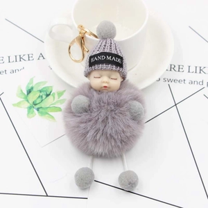 Cute sleeping baby plush keychain with grey knitted hat and fluffy faux fur pompom ball