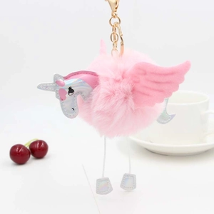 Vue détaillée d'un porte-clés licorne en peluche rose avec mousqueton doré sur blanc