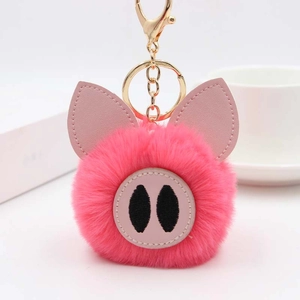 Détail d'un porte-clés cochon en fausse fourrure rose avec fermoir en métal doré brillant