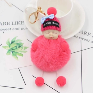 Dettaglio portachiavi bambola che dorme in peluche rosa con berretto e fiocco a scacchi