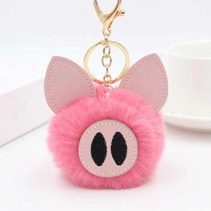 Détail de porte-clés cochon en peluche rose avec fausse fourrure et crochet doré