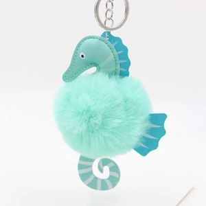 Detail of mint green plush seahorse keychain with soft fur ball and silver ring
