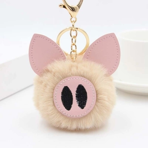 Détail du porte-clés cochon en peluche avec anneau doré et fourrure synthétique brune