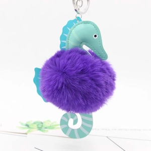 Detail of cartoon seahorse keychain with mint green leather head and purple plush ball