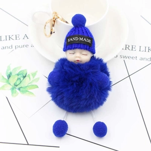 Detail of Klein Blue plush sleeping baby keychain with handmade knit hat and golden clasp