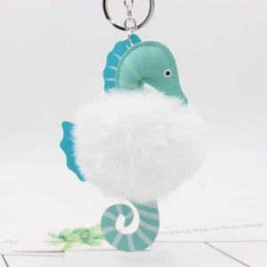 Detail of mint green leather seahorse pendant with soft white faux fur ball keychain