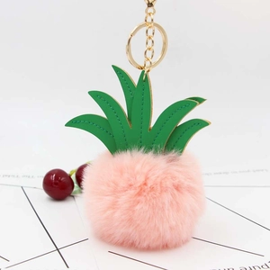 Detail of pink plush pineapple keychain with green PU leaves and gold metal ring link