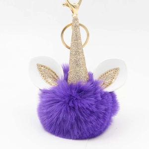 Detailed view of purple plush unicorn keychain with gold horn and lobster clasp
