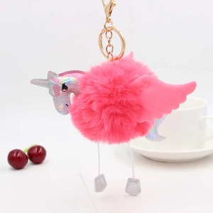 Détail d'un porte-clés licorne en pompon rose avec des ailes argentées irisées