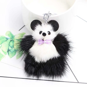 Gros plan d'un pendentif panda en peluche avec nœud papillon violet et anneau argenté
