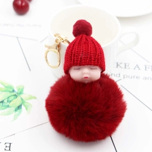 Dettaglio portachiavi bambola neonato che dorme rosso con pompon di peluche e gancio oro