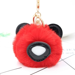 Détail du porte-clés panda rouge en fausse fourrure avec détails en similicuir et anneau doré