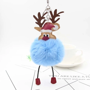 Close-up of reindeer plush keychain with blue faux fur pom pom and leather details
