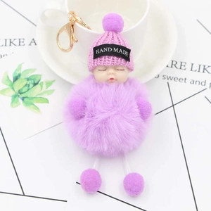 Detail of cute sleeping doll plush keychain with purple faux fur and handmade knit hat
