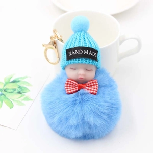 Détail du porte-clés bébé endormi en fourrure bleue avec bonnet tricoté et fermoir doré