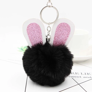 Détail d'un porte-clés lapin noir en fausse fourrure avec oreilles pailletées roses