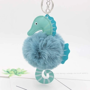 Detail of blue plush seahorse keychain with soft fur ball and silver metal ring