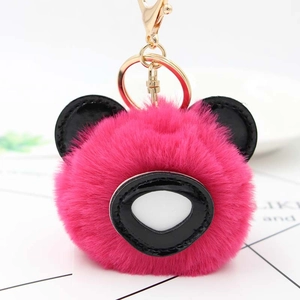 Vue macro du porte-clés panda en peluche rose avec fermoir doré en métal de qualité
