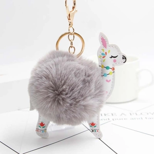 Gray plush alpaca pompom keychain with white floral leather accents and gold hardware