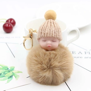 Portachiavi con neonato dormiente di peluche con pompon e cappello in maglia rosa