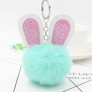 Porte-clés lapin en peluche vert menthe avec oreilles pailletées sur fond blanc