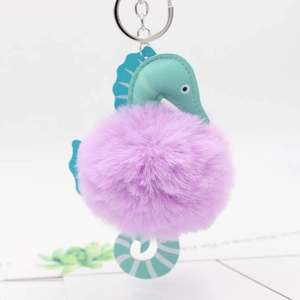 Detail showing plush seahorse keychain with mint green faux leather and purple faux fur ball