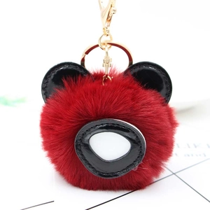Vue détaillée du porte-clés ours en peluche rouge foncé avec des accents en similicuir noir