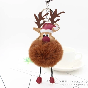 Detail of Christmas reindeer faux fur pompom keychain with leather antlers and metal clasp