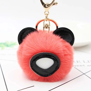 Gros plan du porte-clés ours en peluche corail avec oreilles noires et anneau doré