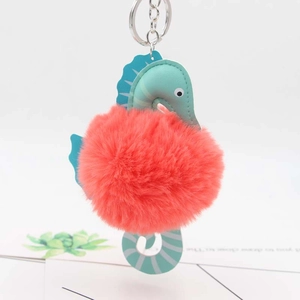 Detail of coral red plush pompom seahorse keychain with cyan leather and silver clip