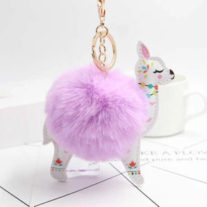 Detail of a purple faux fur alpaca keychain with floral pattern and golden metal clip