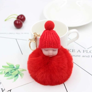 Simpatico portachiavi neonato che dorme con pompon rosso di peluche e anello dorato